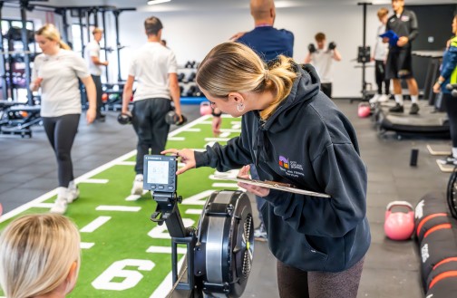 Sports student standing at the rower, measuring performance