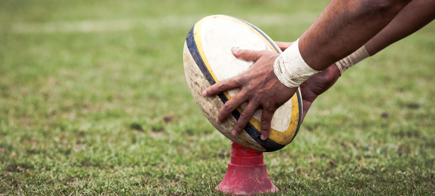 Person placing rugby ball on cone