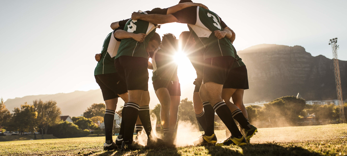 Rugby players huddling on rugby field